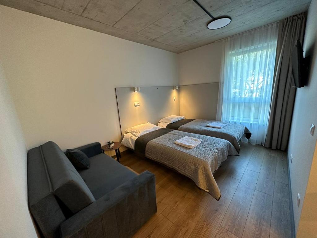 克莱佩达Tilzes Studio apartaments, Self check-in, Free parking, Comfort的一间带两张床和一张沙发的客厅