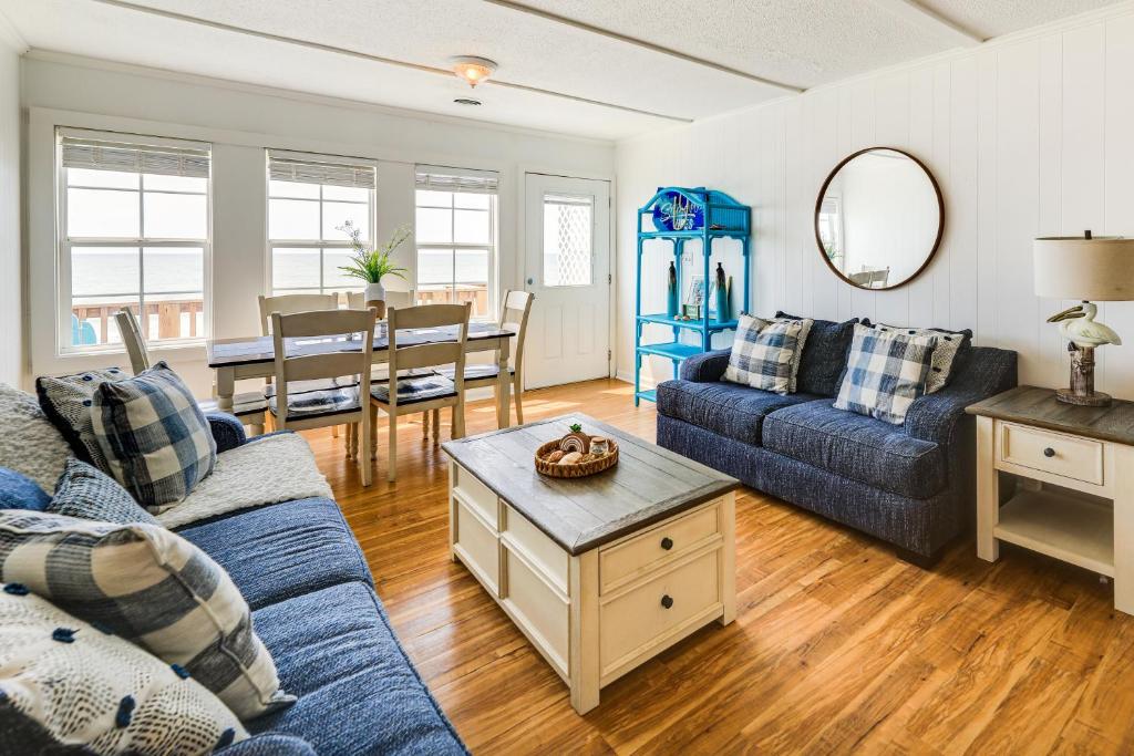 翡翠岛Beachfront Emerald Isle Vacation Rental with Deck!的客厅配有蓝色的沙发和桌子