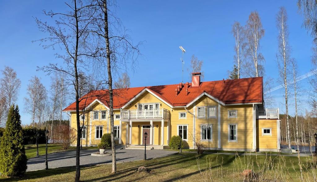 HuutotöyryLossirannan Kartano的红色屋顶的大型黄色房屋