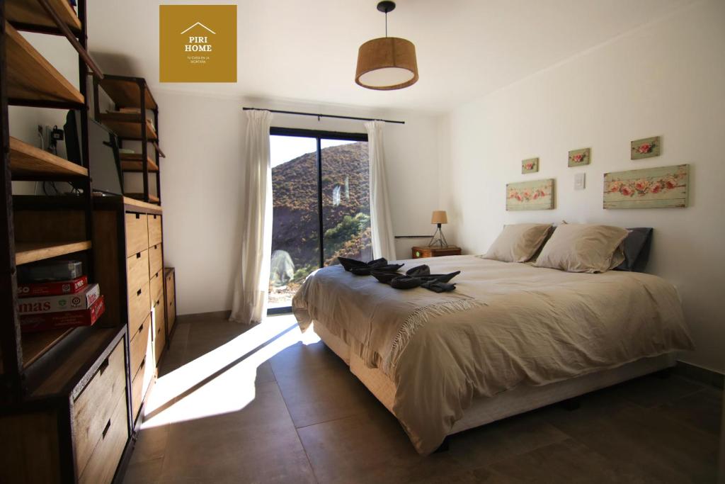 洛斯莫莱斯Piri Home Casa de Montaña的一间卧室设有一张大床和一个大窗户