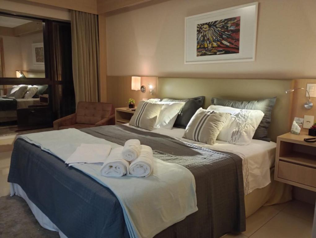 巴西利亚Flat Premium Particular Cullinan Hotel的酒店客房,配有带毛巾的床