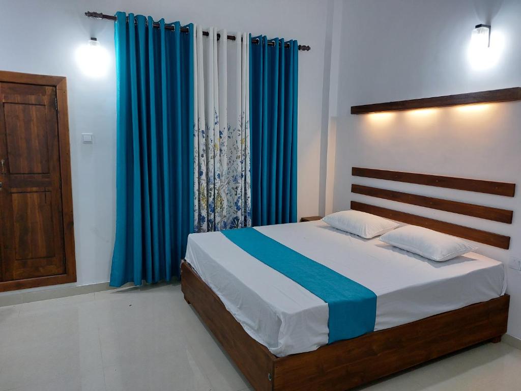 阿努拉德普勒Green Shield Resort的一间卧室配有蓝色窗帘的床
