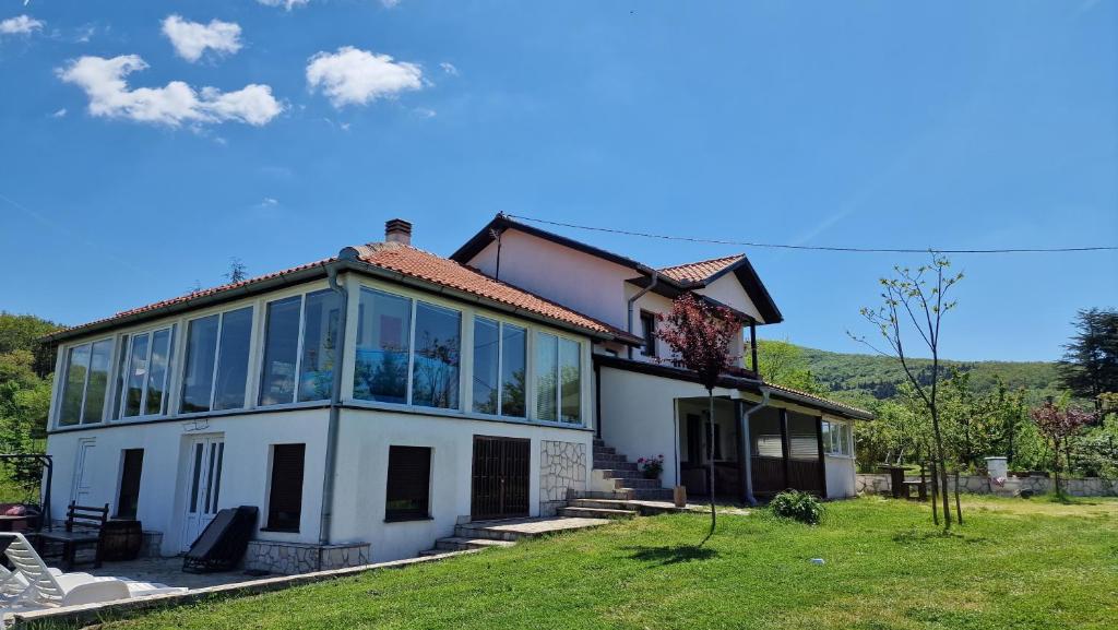 NemenikućeMeriland Kosmaj的大型白色房屋,在田野上设有大窗户