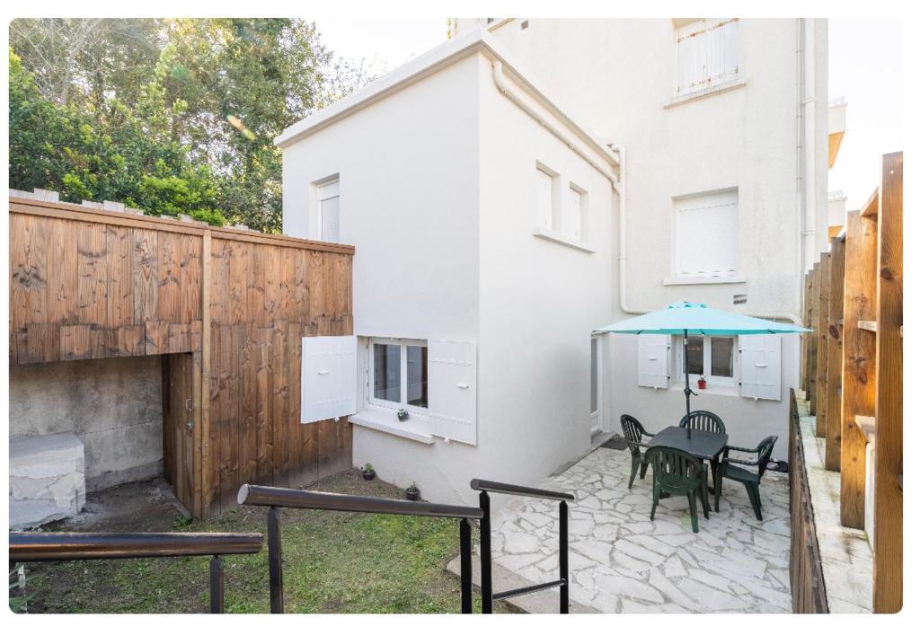 鲁瓦扬Appartement 200 m plage avec terrasse et jardin的一个带桌子和蓝伞的庭院
