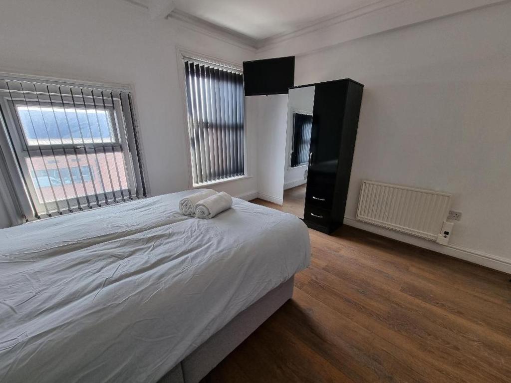 利物浦PL Liverpool的一间卧室设有一张大床和两个窗户。
