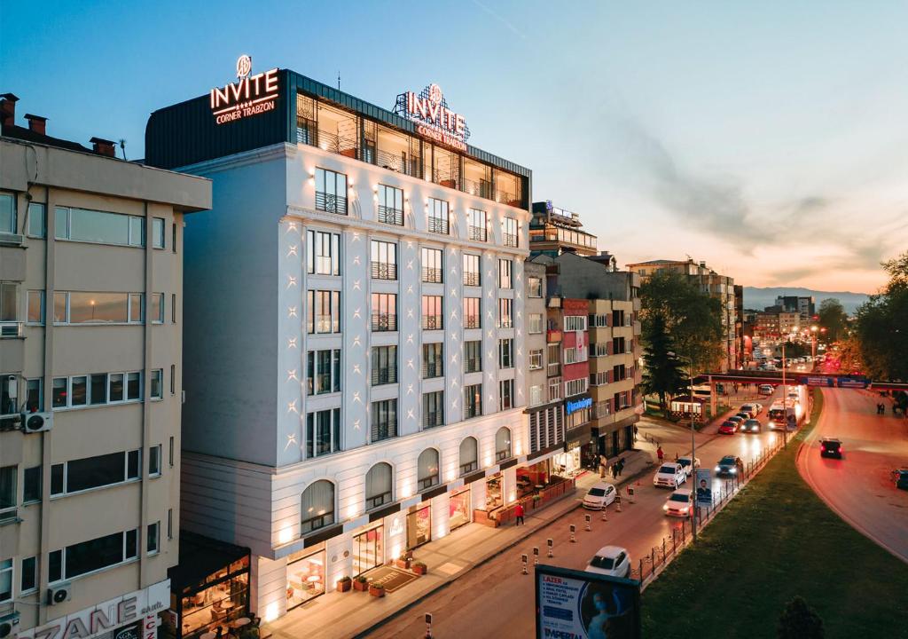 特拉布宗Invite Hotel Corner Trabzon的一条有汽车的城市街道上白色的大建筑