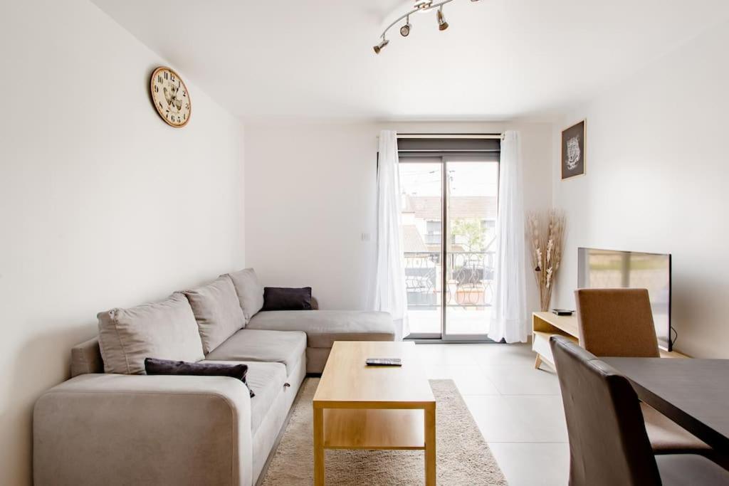 摩兰吉斯Joli appartement proche Paris Orly的客厅配有沙发和桌子