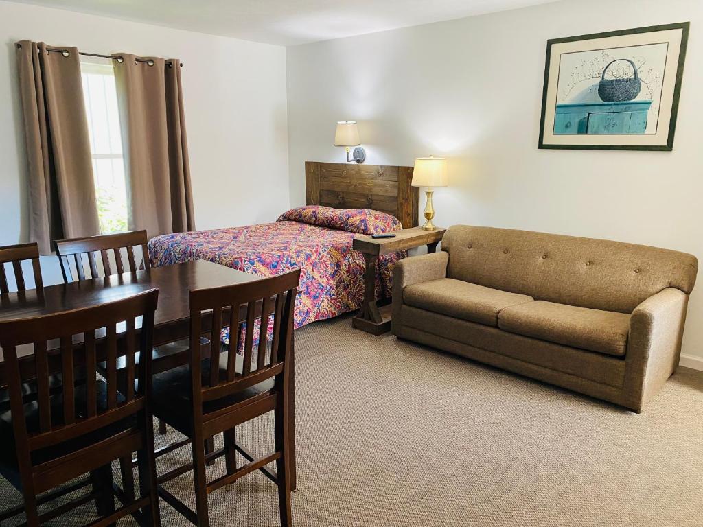 缪尼辛Scotty's Motel的一间卧室配有一张床、一张沙发和一张桌子