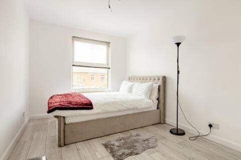 伦敦Lovely and comfortable Home Stay in London的白色的卧室设有床和窗户
