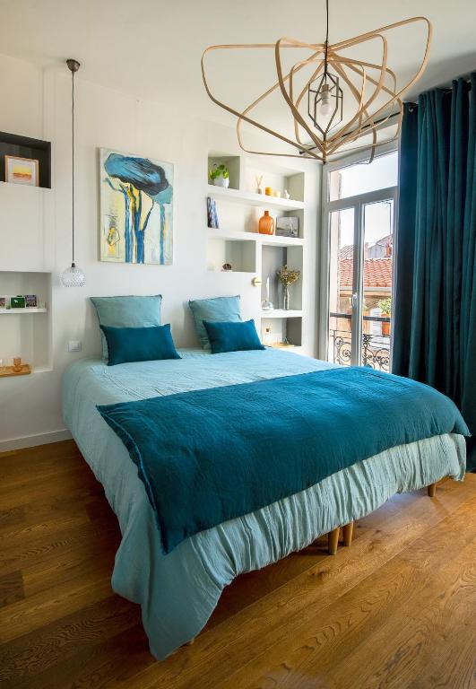 马赛La Maison Vague - Guest House的卧室内的一张大床,配有蓝色毯子