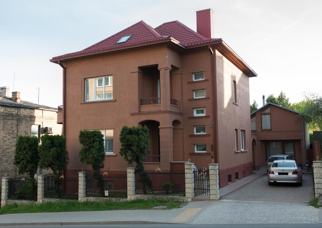 考纳斯Petro delux apartments center的一间棕色的房子,前面有一辆汽车