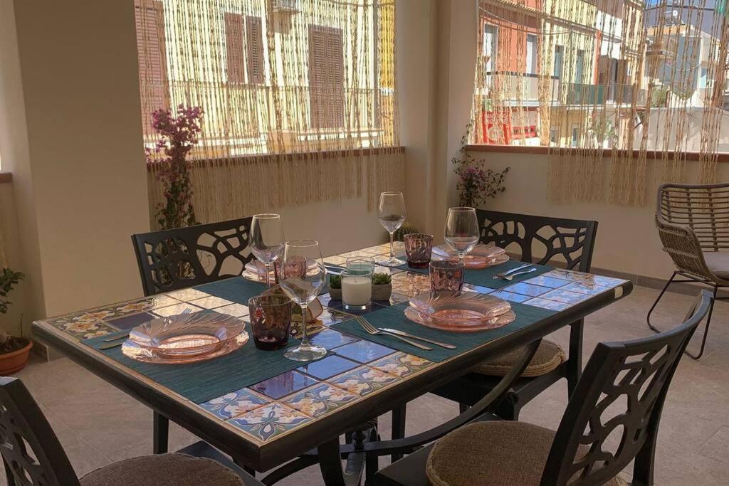 马尔扎梅米Casa Franca a Marzamemi的一张桌子上放有盘子和酒杯