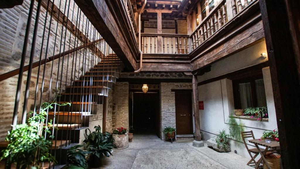 托莱多Tiempo de Toledo的一座种植了植物的古老建筑的室内走廊