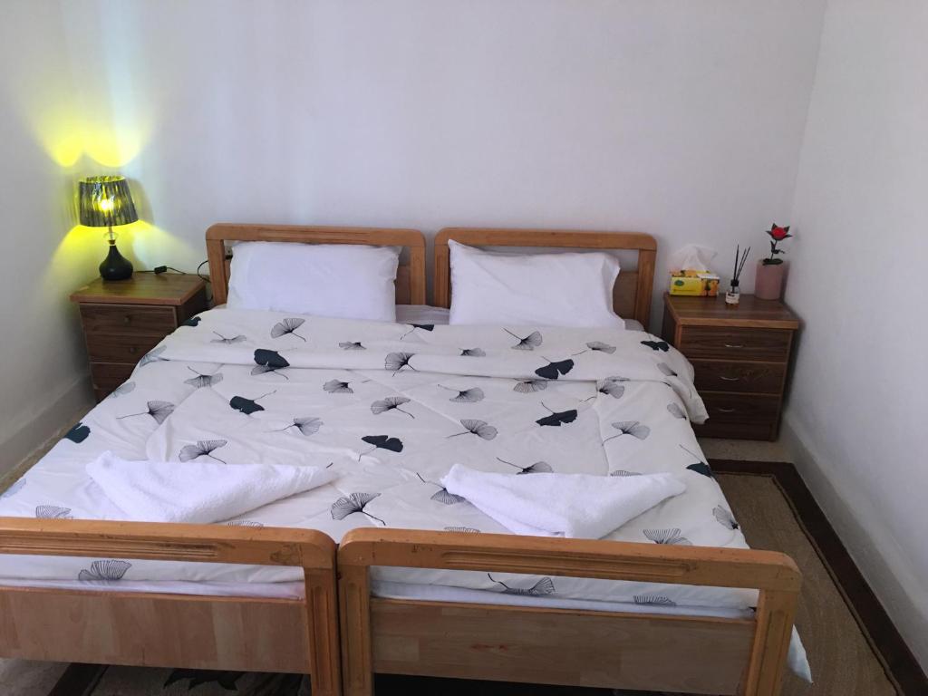 乌姆盖斯بيت العُمري (ام قيس)的一间卧室配有一张铺有白色床单的床,床上有鸟儿