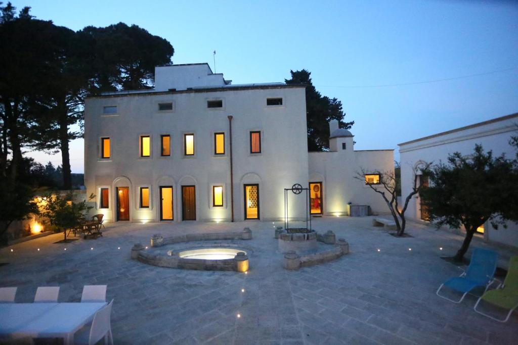 库特罗菲安诺Villa Lucrezio Resort的一座白色的大建筑,前面有一个庭院