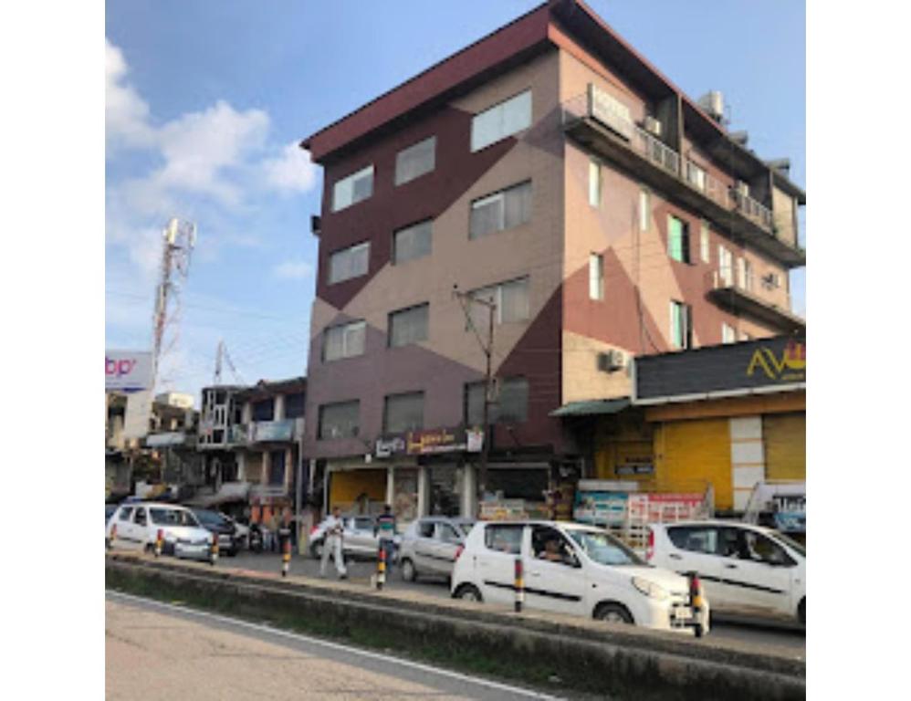 康格拉Hotel lords Highway Inn, Gagal Khas的一座高大的建筑,汽车停在城市街道上