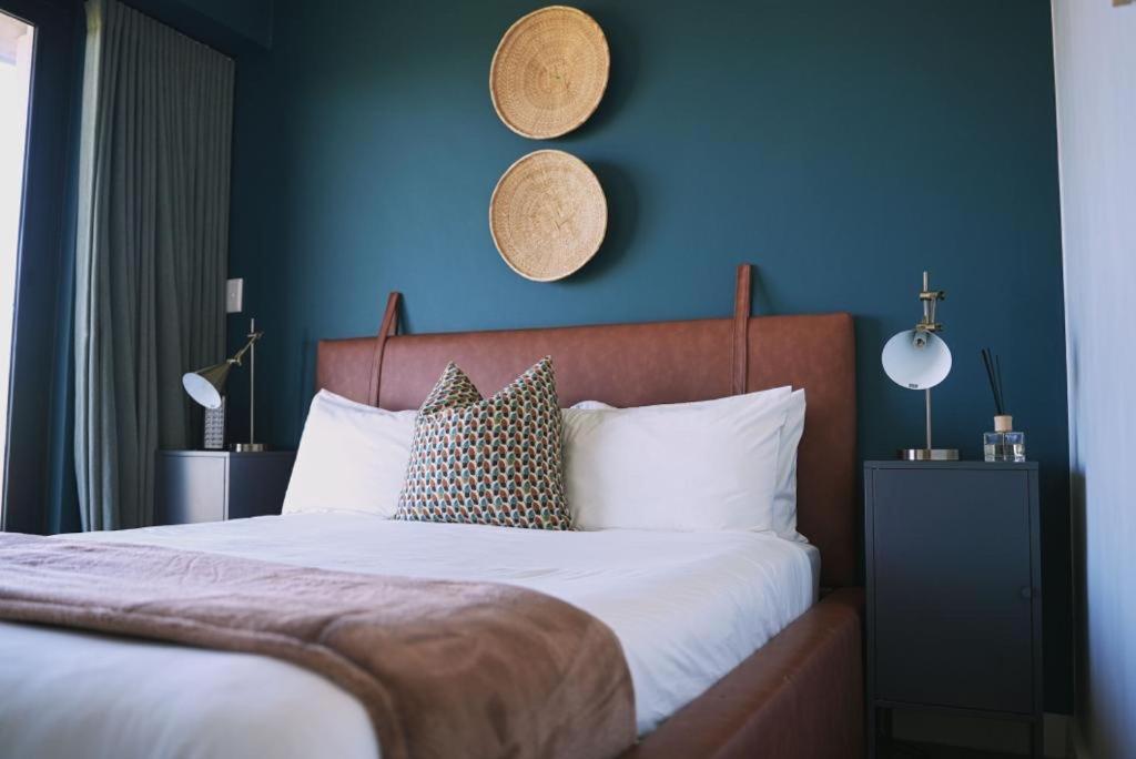 开普敦Rose Gold @The Winchester的一间卧室设有一张蓝色墙壁的大床