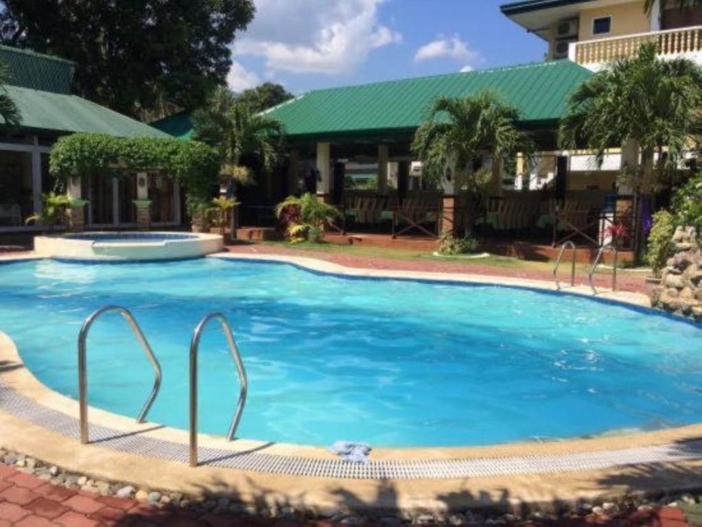 波尔多·格尼拉La Solana Suites and Resorts by Cocotel的一座大蓝色游泳池,位于房子前
