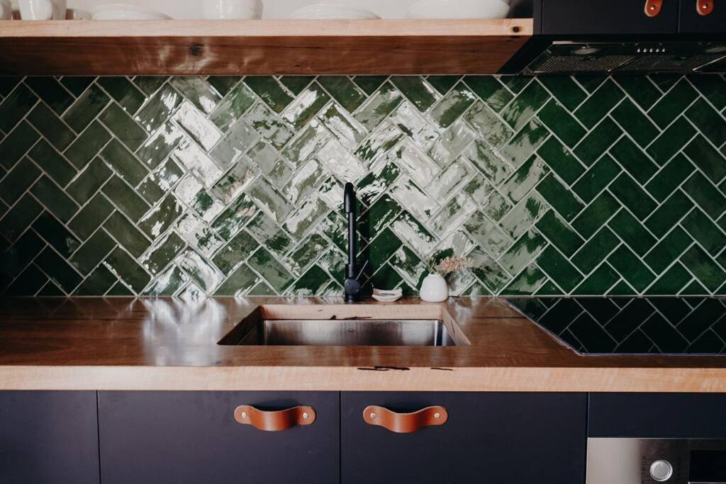 奥尔巴尼View Street Studios - Yarri的厨房设有水槽和绿色瓷砖墙。