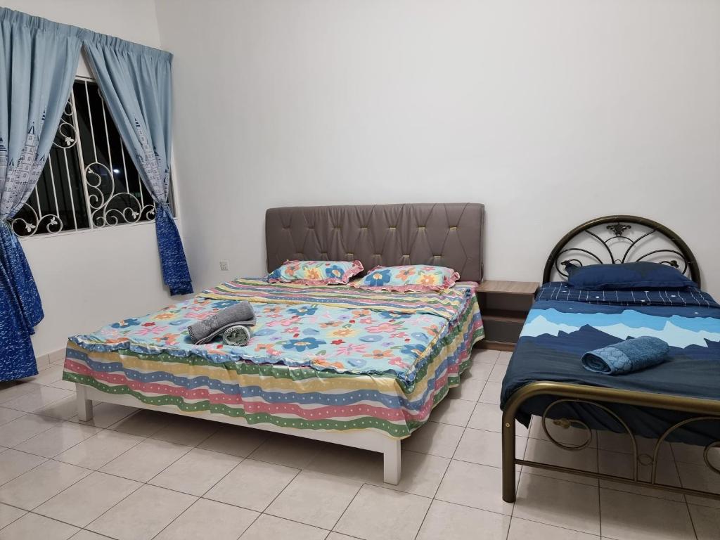 山打根Sweethome Homestay Sandakan的一间卧室设有两张床和窗户。
