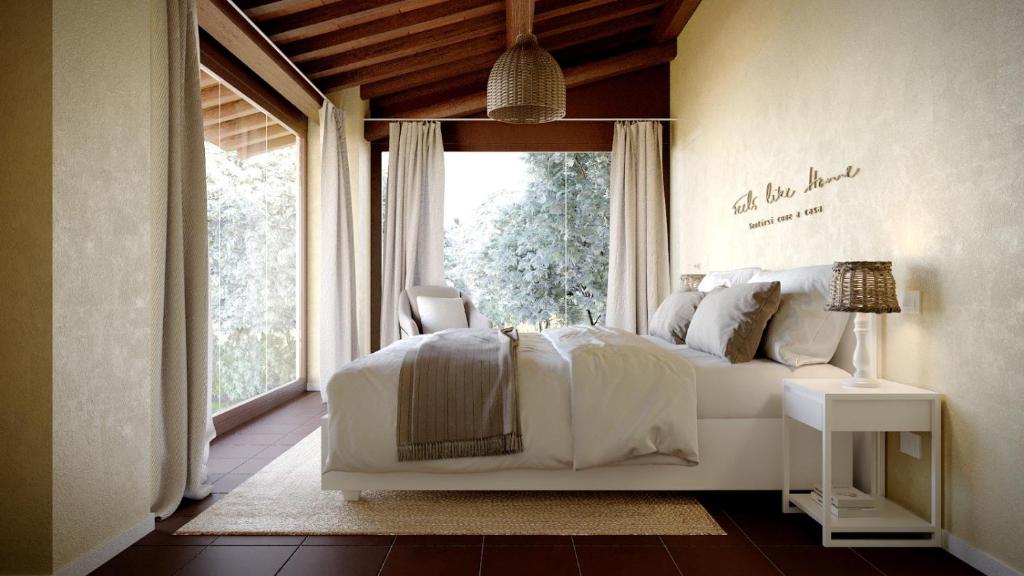 阿夸维瓦皮切纳Villino Gentile的卧室配有白色的床和窗户。