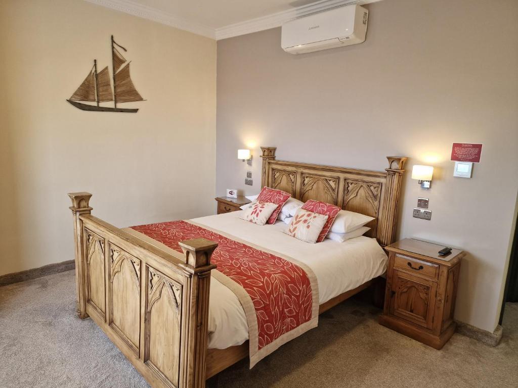 雷德卡克拉克斯顿酒店的卧室配有一张床,墙上有一条船
