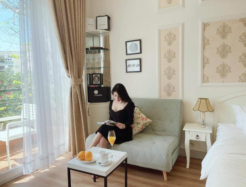 胡志明市Chez Lotus Rose的坐在客厅沙发上的女人