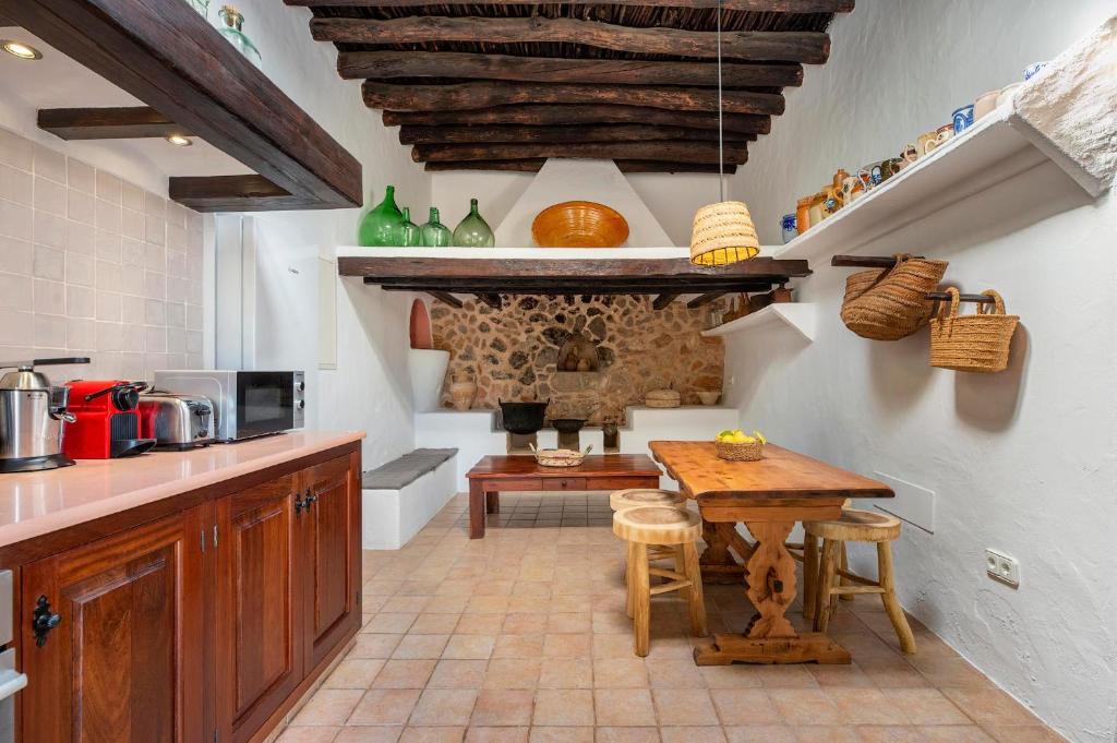 圣埃乌拉利亚Can Mateu的一间带木桌的厨房和一间餐厅