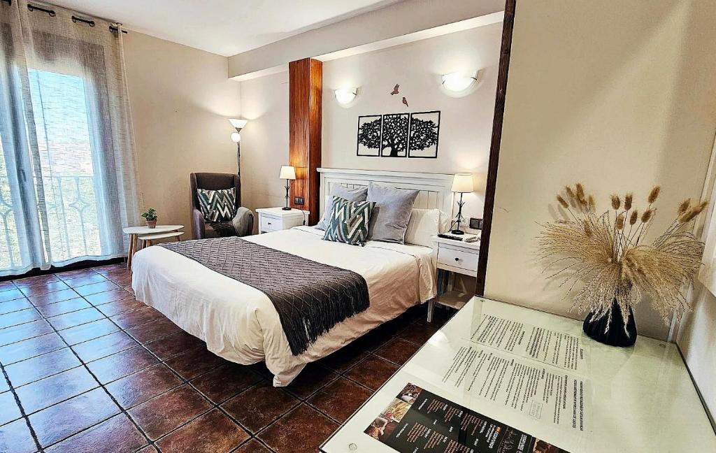 托莱多托雷多老城酒店的一间卧室配有一张床和一张桌子及一本书