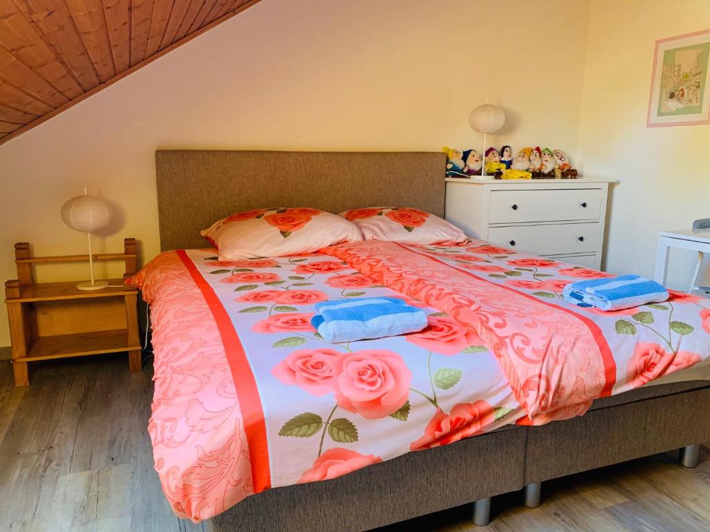 东卡佩勒B&B Oostkapelle aan Zee的一间卧室,床上有粉红色的鲜花