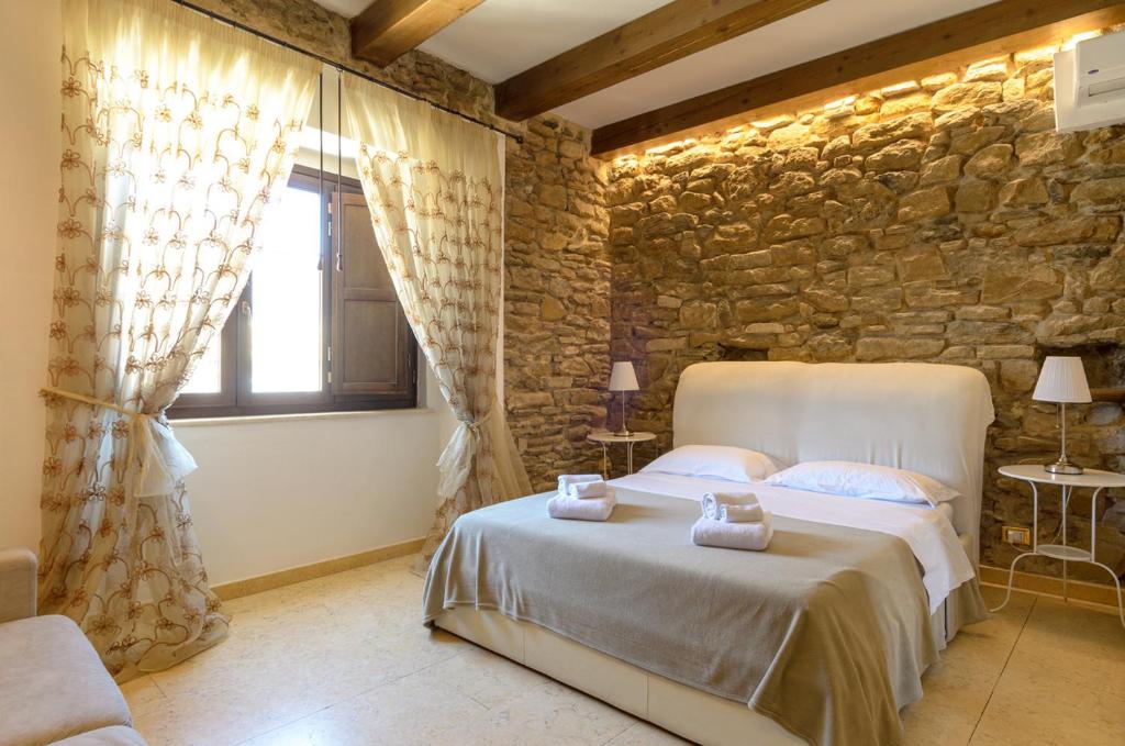 泰尔莫利斯坦泽迪卢多维卡住宿加早餐旅馆的一间卧室设有一张床和石墙