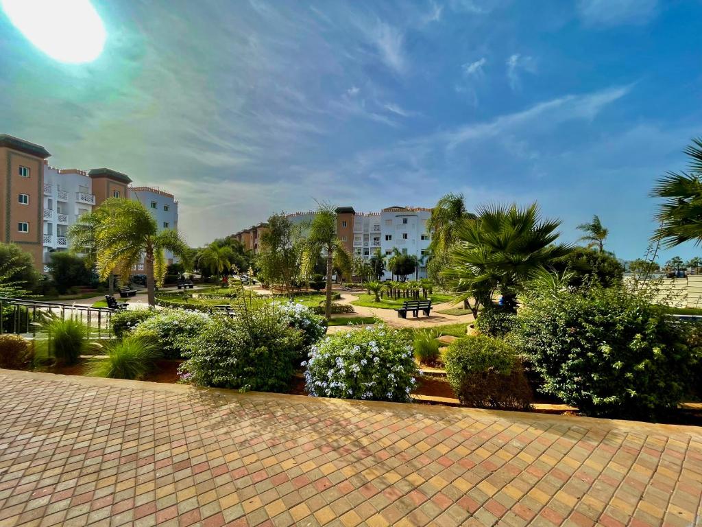 穆罕默迪耶Résidence Al Kawtar的公园里布满灌木丛、树木和建筑,阳光灿烂