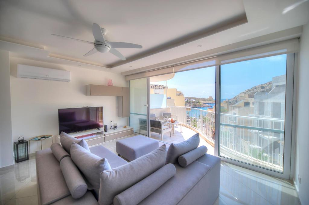 克伦蒂Seaside apartment in the heart of Xlendi Gozo的带沙发和大窗户的客厅