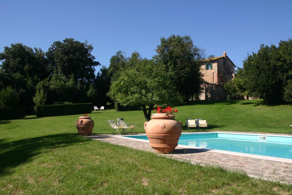 PalazzoneAgriturismo Spazzavento的两个花瓶,在泳池旁