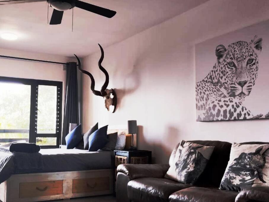 乌姆德洛蒂Modern African surf bachelor unit的客厅配有一张床和一张豹子的照片