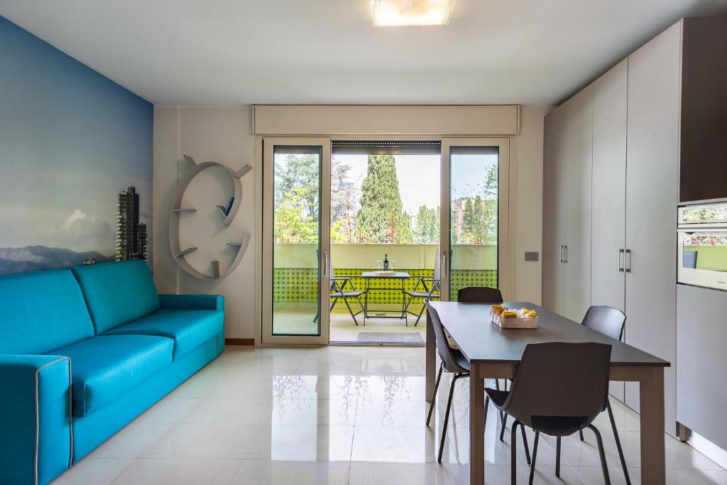 米兰APPARTAMENTO MACIACHINI, ZONA ISOLA的客厅配有蓝色的沙发和桌子