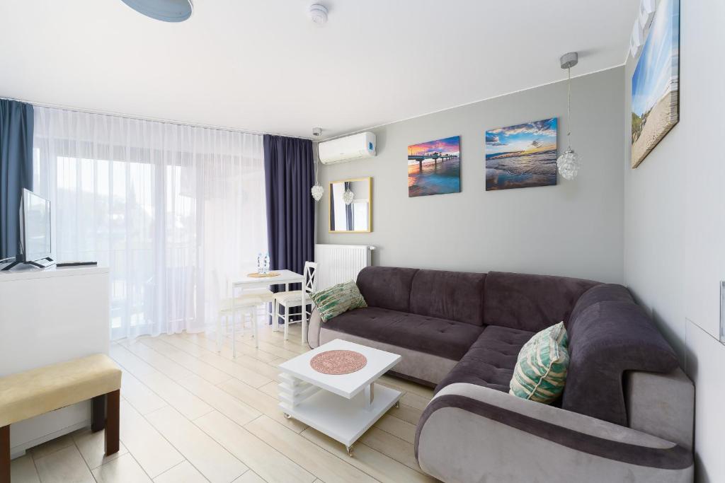 米兹多洛杰Horyzont Apartament z Klimatyzacją i Balkonem by Renters的客厅配有沙发和桌子