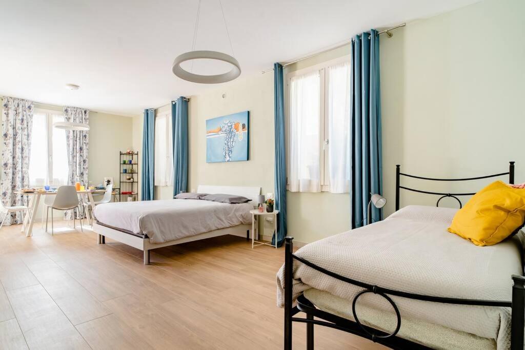 Rodengo Saiano弗昂斯艾克塔罗德恩格赛诺住宿加早餐旅馆的一间卧室配有两张带蓝色窗帘的床和一张桌子