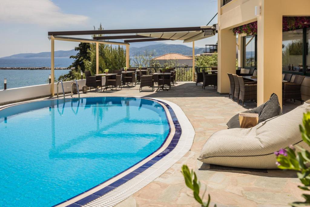 凯米Griffon Kymi Hotel previously known as Valledi Village的一个带桌椅的庭院内的游泳池