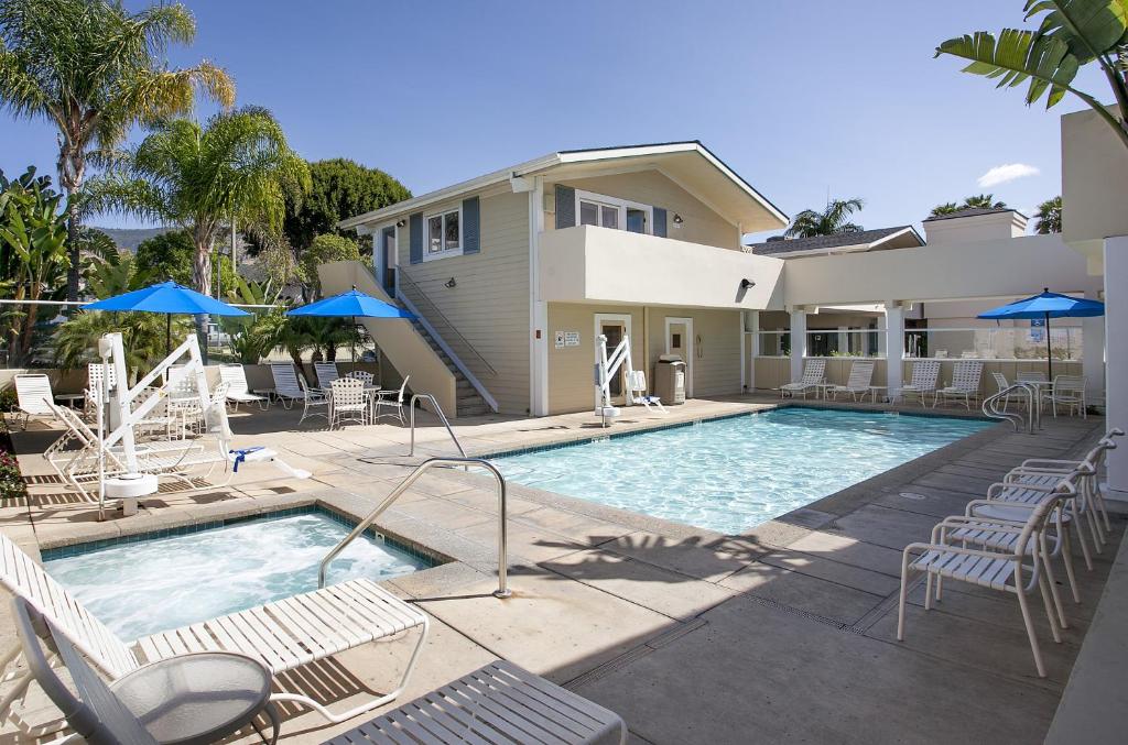 圣巴巴拉圣巴巴拉胜佰德旅舍的一个带椅子的游泳池以及一座房子