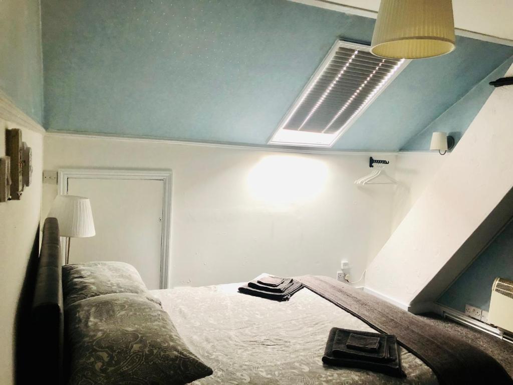 罗奇福德AC Hideout的一间卧室配有一张床和吊扇