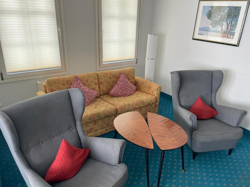 赛巴特班森kleiner Seehof - FeWo 01的客厅配有两把椅子和一张沙发