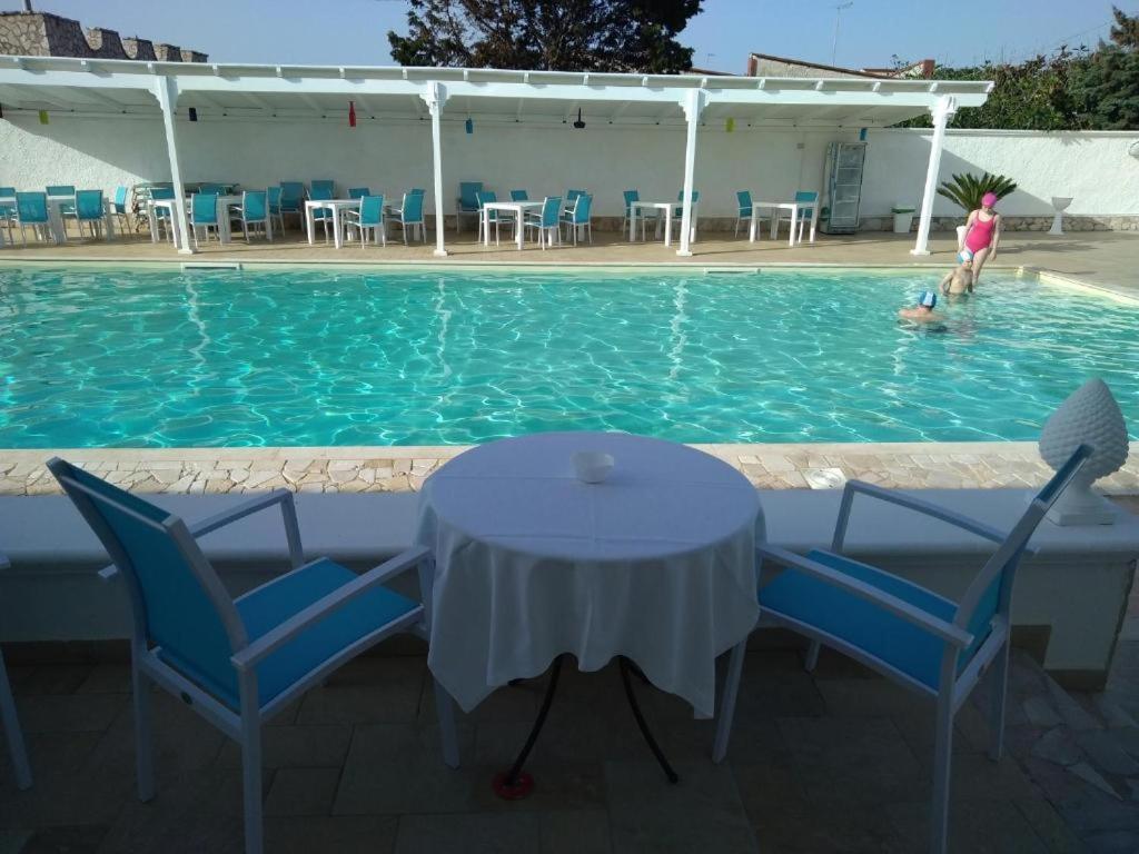 普尔萨诺伊尔加利欧奈B&B酒店的游泳池内的桌椅