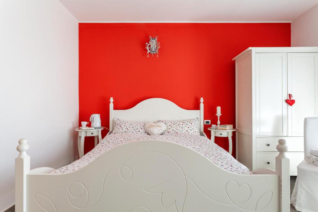 卡萨诺韦Malpensa Garden的一间红色的卧室,配有白色的床和红色的墙壁