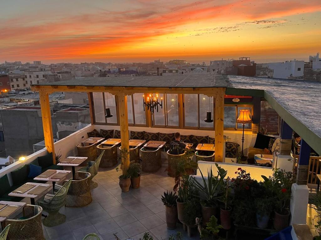 索维拉大西洋旅馆 的日落时分带桌椅的屋顶露台
