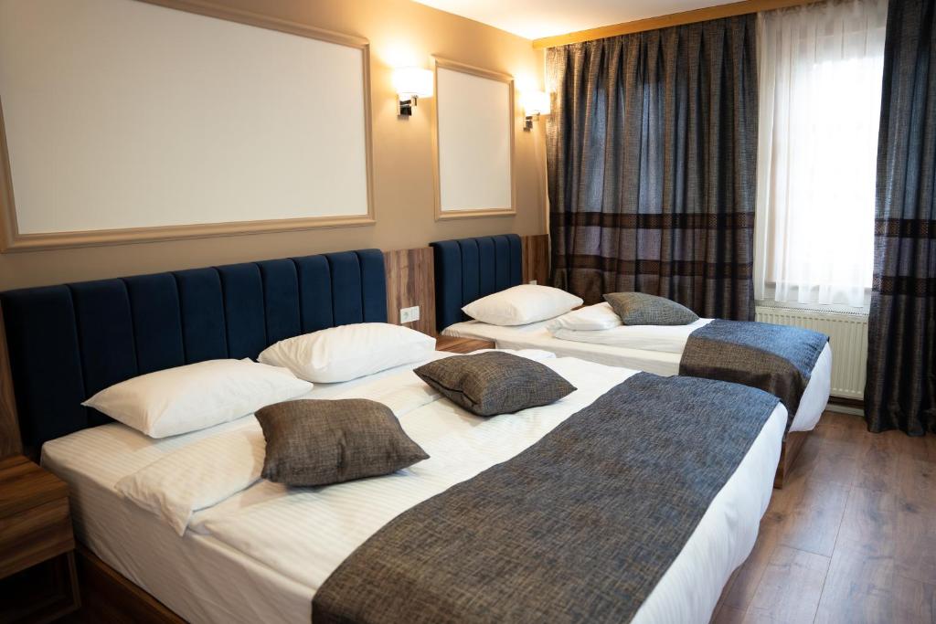 萨拉热窝Amber Hotel的酒店客房设有两张床和窗户。