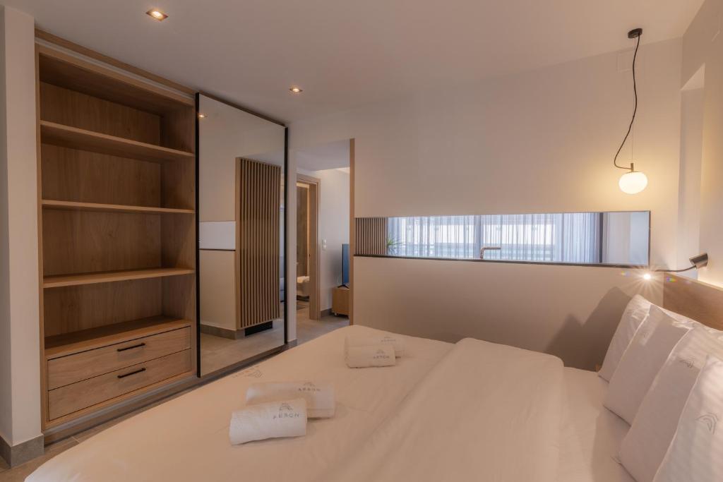 沃洛斯Aeson Premium Living的卧室配有一张白色大床和镜子
