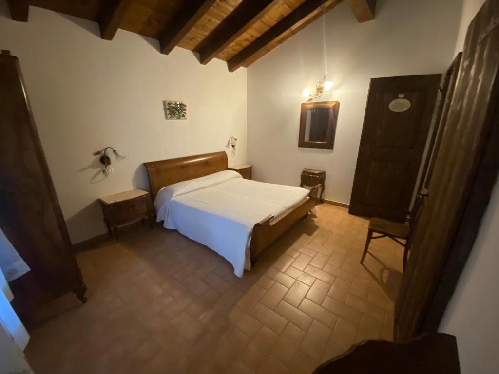 MonzunoAgriturismo Prunara Farmstead F.lli Santoli的卧室配有白色的床和椅子
