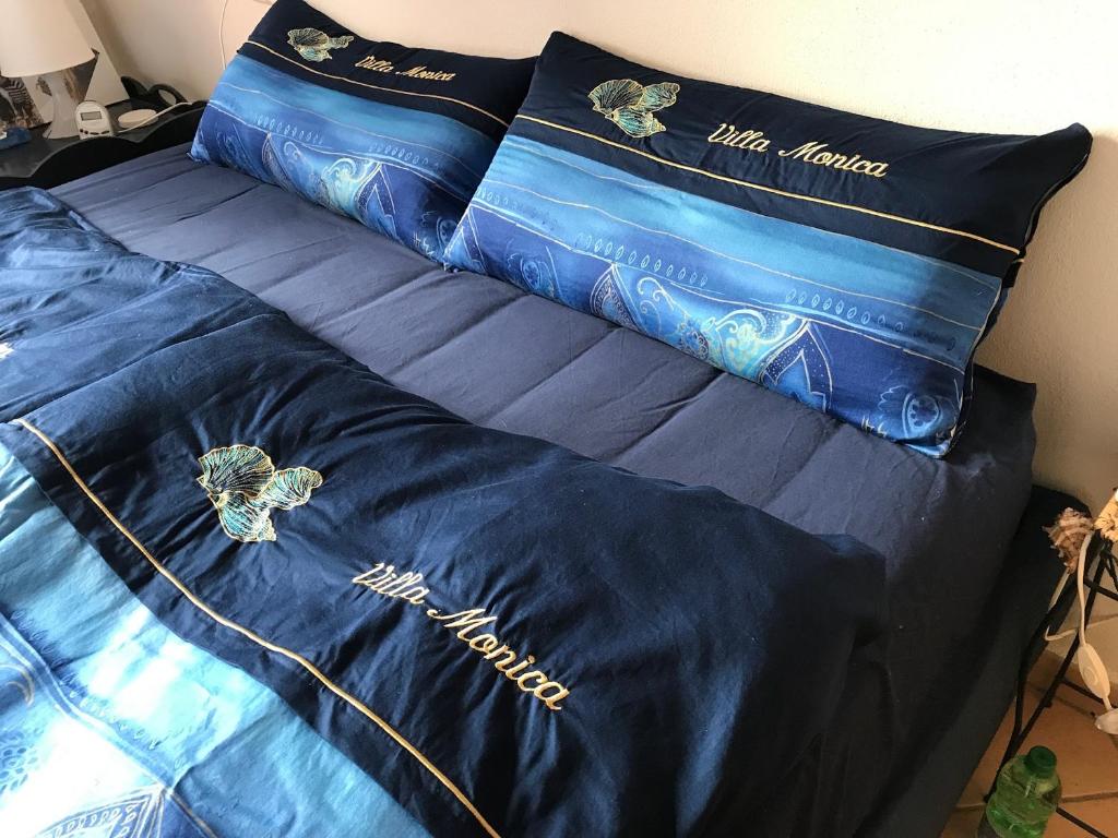 卡波利韦里Villa mit Whirlpool und phantastischer Aussicht的一张带蓝色床单和枕头的床