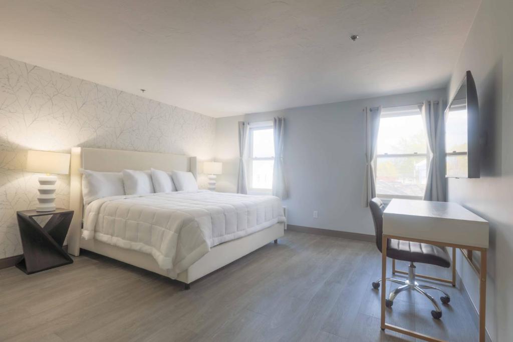 韦斯特伯鲁韦斯特伯勒旅舍的卧室配有白色的床、书桌和窗户。
